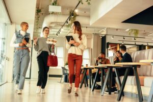Employees walking and talking in a modern office lounge, representing authentic workplace culture for a recruiting video
